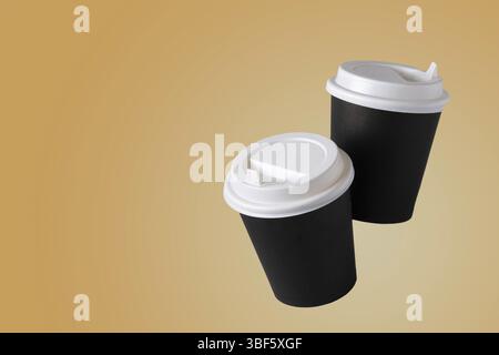 A pair of paper coffee cups flying on a yellow background, copy space Stock Photo