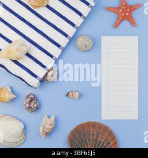 Creative square flat lay concept of summer travel vacations. Top view of beach towel and seashells and starfish on pastel blue background with copy sp Stock Photo