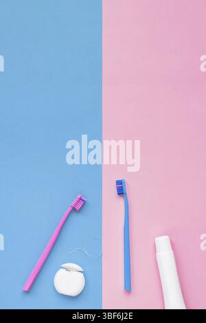 Teeth hygiene and oral dental care products on color pink and blue background with copy space. Blank tube of toothpaste and brushes. Flat lay, top vie Stock Photo