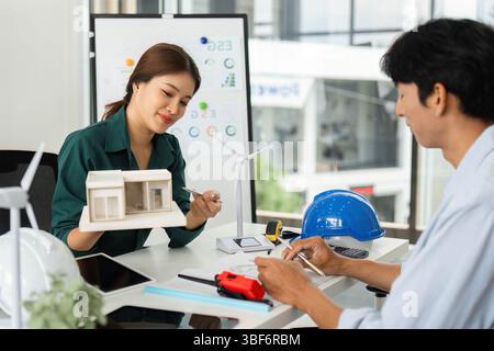 Collaborative ESG Discussion. Two professionals exploring sustainable architecture and renewable energy solutions. Stock Photo