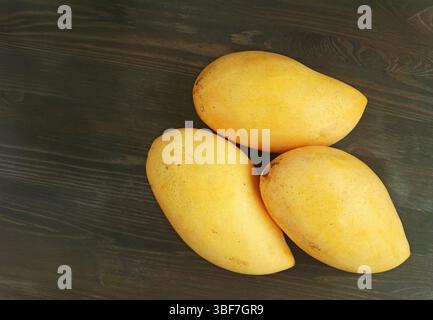 Fresh Ripe Mango Fruits Isolated on Black Wooden Table Stock Photo