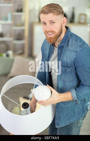 man changing compact-fluorescent cfl bulbs Stock Photo