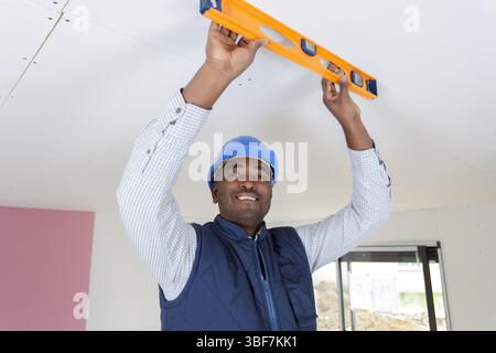taking measures with spirit level on the ceiling Stock Photo