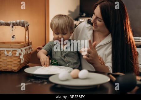 Easter kitchen fun with mom and toddler creating holiday crafts through messy play gentle parenting and mindful bonding making sweet spring memories Stock Photo