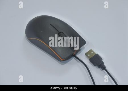 a black wired mouse with orange stripes made of plastic, with a gray background as an interactive controller on the computer Stock Photo