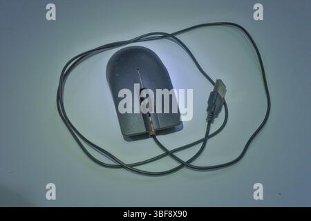a black wired mouse with orange stripes made of plastic, with a gray background as an interactive controller on the computer Stock Photo
