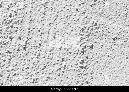 Close-up of a white wall with a rough, textured surface. Small, pointed protrusions cast shadows, creating contrast. Stock Photo