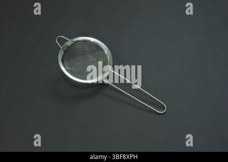 Tea and coffee filters are made of stainless steel, looking sturdy with a shiny silver light on a dark background color. Stock Photo
