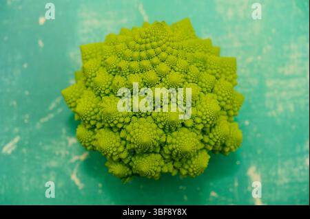 Romanesco broccoli vegetable on green backdrop Stock Photo