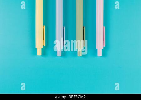 Top view of colorful pens on blue background. School, office wallpaper. Flat lay, copy space. Stock Photo