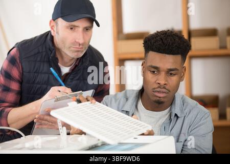 men working tpgether on printer Stock Photo