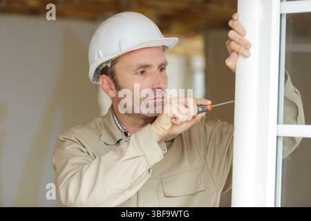 smiling man is fixing a window handle Stock Photo
