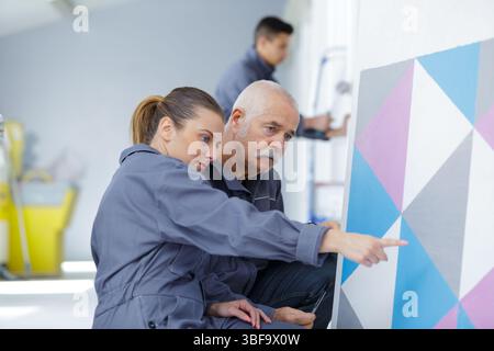 painter with apprentice in training room Stock Photo