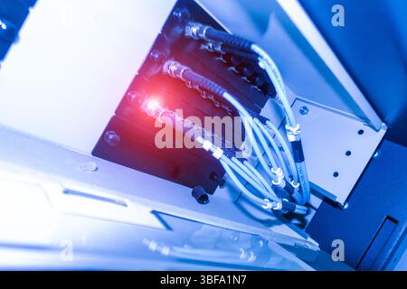 This image showcases a close-up view of advanced laser technology connected through intricate cables, featuring illuminated components. Perfect for an Stock Photo