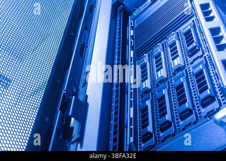 Explore the interior of a modern data center showcasing high-tech server racks illuminated by blue lights, emphasizing innovation and connectivity in Stock Photo