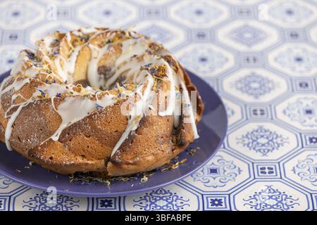 Marble bundt cake, cake with icing and edible flowers on a blue plate Stock Photo