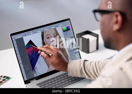 Professional Photographer Edits Vibrant Graphic Designs On Black Laptop. Stock Photo