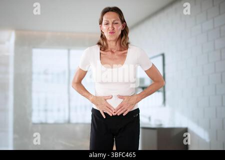 Woman Holding Stomach With Pain, Feeling Nauseous During Ectopic Pregnancy. Stock Photo