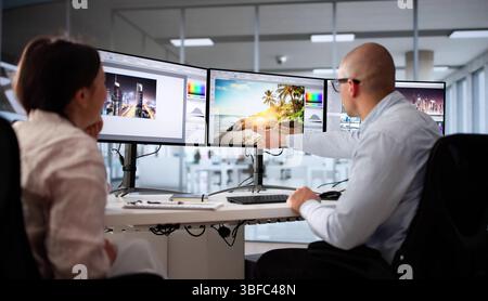 Busy Graphic Designer Creating Artwork On Dual Monitors In Office. Woman Working On Photo Editing Project Stock Photo