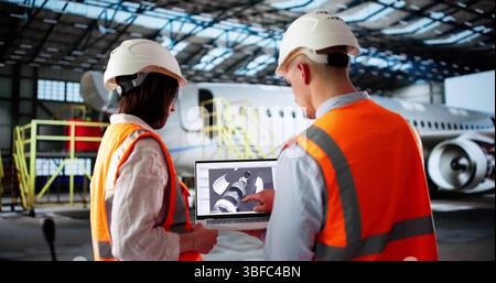 Mechanical Engineer Inspects A Jet Engine At The Airport Hangar. Stock Photo