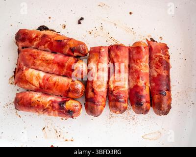 top view of sausages wrapped in bacon baked in oven in white ceramic form Stock Photo