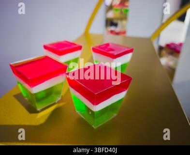 Layered jelly dessert in red white and green served in plastic cups Stock Photo