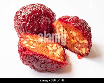 red Alani Armenian sweet with nuts, made from dried plums with addition of honey, on white plate close up Stock Photo