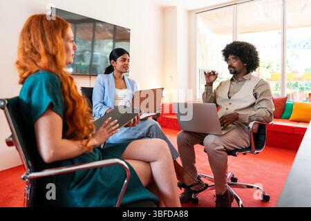 Multiethnic small group of businesspeople meeting in a coworking corporate company office - Young coworkers colleagues working together in a creative Stock Photo