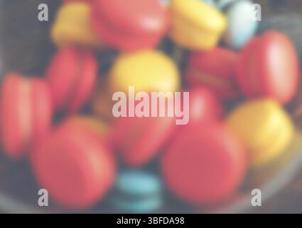 Bright macaroons in a glass bowl. Defocused shot Stock Photo