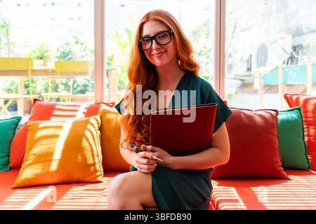 Beautiful caucasian business woman working in a coworking corporate company office - Young female wearing business casual clothing works in a creative Stock Photo
