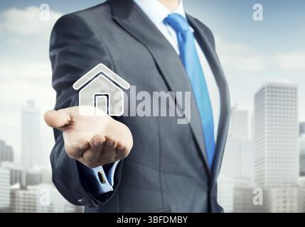 Hand of businessman showing house sign in palm Stock Photo - Alamy