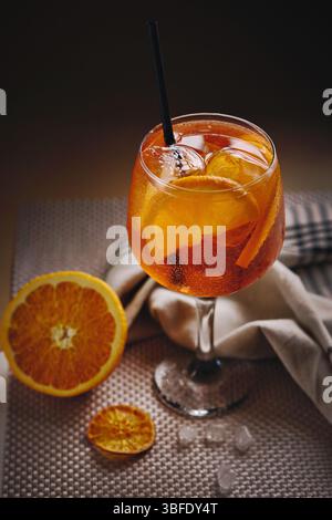 Close up of Aperol Spritz cocktail beautifully served in glass with ice cubes and orange slices, vertical shot Stock Photo