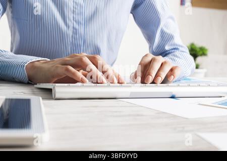 Manager typing on computer keyboard at wooden desk. Strategy planning and banking. Financial analyst working in office. Business accounting and projec Stock Photo