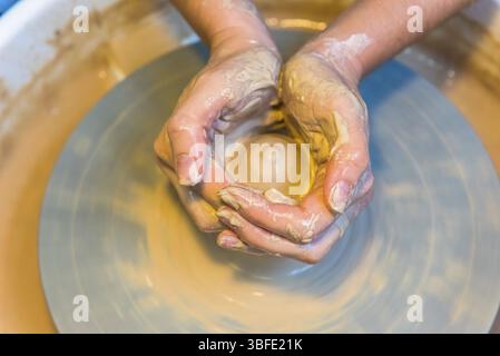 Pottering - creating a clay cup in process. Shot with a small GRIP Stock Photo