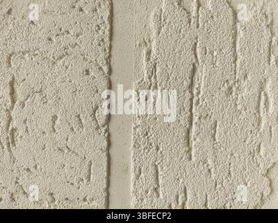 Two sections of a wall exhibit different textured plaster finishes, showcasing a blend of smooth and rough surfaces in a light neutral color, highligh Stock Photo