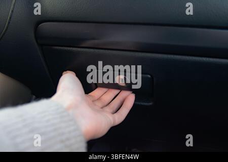 Hand female open glove compartment box in car. Car interior. Stock Photo