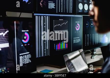 Stock market analysts monitoring real-time data, charts, and graphs Stock Photo