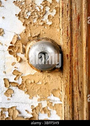Old electrical switch mounted on weathered wood with peeling paint in a rustic setting Stock Photo