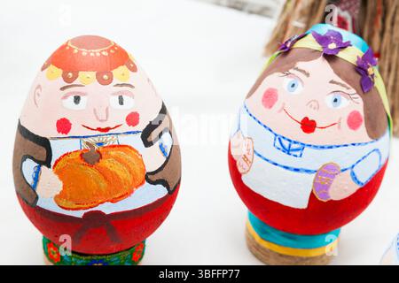 two eggs painted with bright colors in the form of peoples faces. Stock Photo