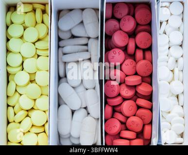 Four packages with multi-colored pills close-up. Stock Photo