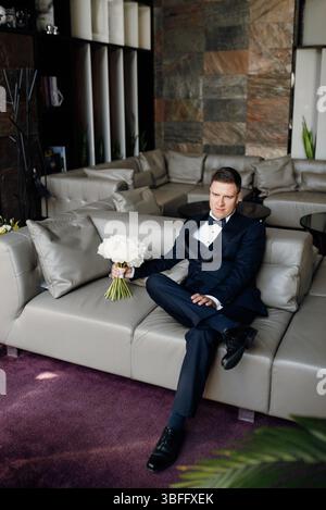 portrait of groom in blue tuxedo in hotel interior Stock Photo