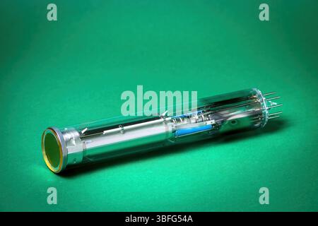 vintage video camera tube (Vidicon) with detailed internal components against a green background Stock Photo