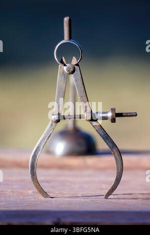 antique oil can and compass covered in dirt on a rustic wooden base. Vertical Stock Photo