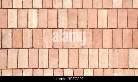 Close-up full-frame classic red brick wall, fired clay bricks arranged in a uniform horizontal pattern. Textured surface and rustic tone. Masonry. Stock Photo