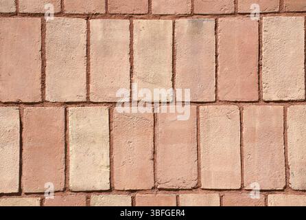 Close-up full-frame classic red brick wall, fired clay bricks arranged in a uniform horizontal pattern. Textured surface and rustic tone. Masonry. Stock Photo