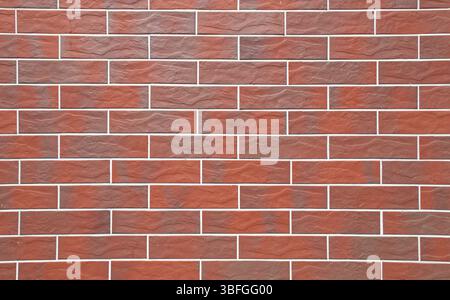 Full-frame close-up image, red brick tile wall with clean grout lines and a uniform pattern. Modern masonry texture, smooth ceramic surfaces. Stock Photo
