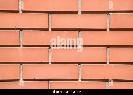 Close-up full-frame of a red brick wall, horizontal pattern. Clay brick wallpaper with cement joints. Background, construction project, wallpaper. Stock Photo