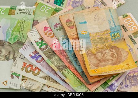 A collection of colorful banknotes in varying denominations is arranged on a flat surface, showcasing the diverse design and value of the currency. Stock Photo