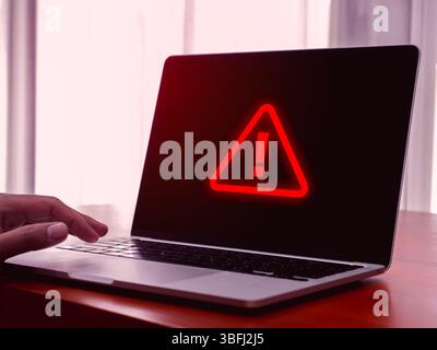 Virus alert. Red triangle, system hacked error sign, malware, attention danger symbol, system error, warning showing on screen display of laptop compu Stock Photo