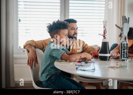 Father and son working on robotic car together. STEM concept. Stock Photo